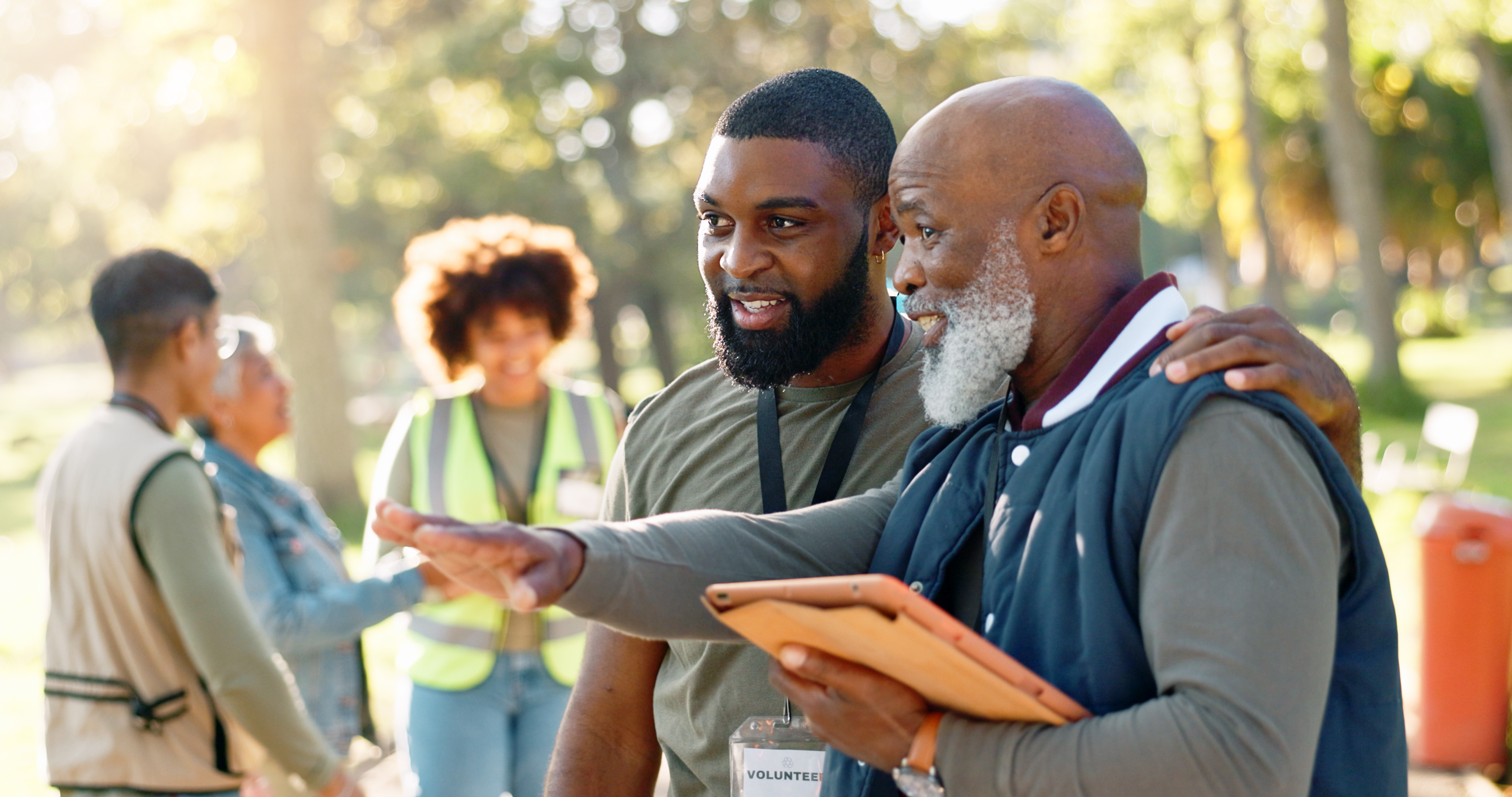 Group of diverse volunteers discussing strategies in a park, emphasizing community service and support in managing Texas misdemeanor assault fines.